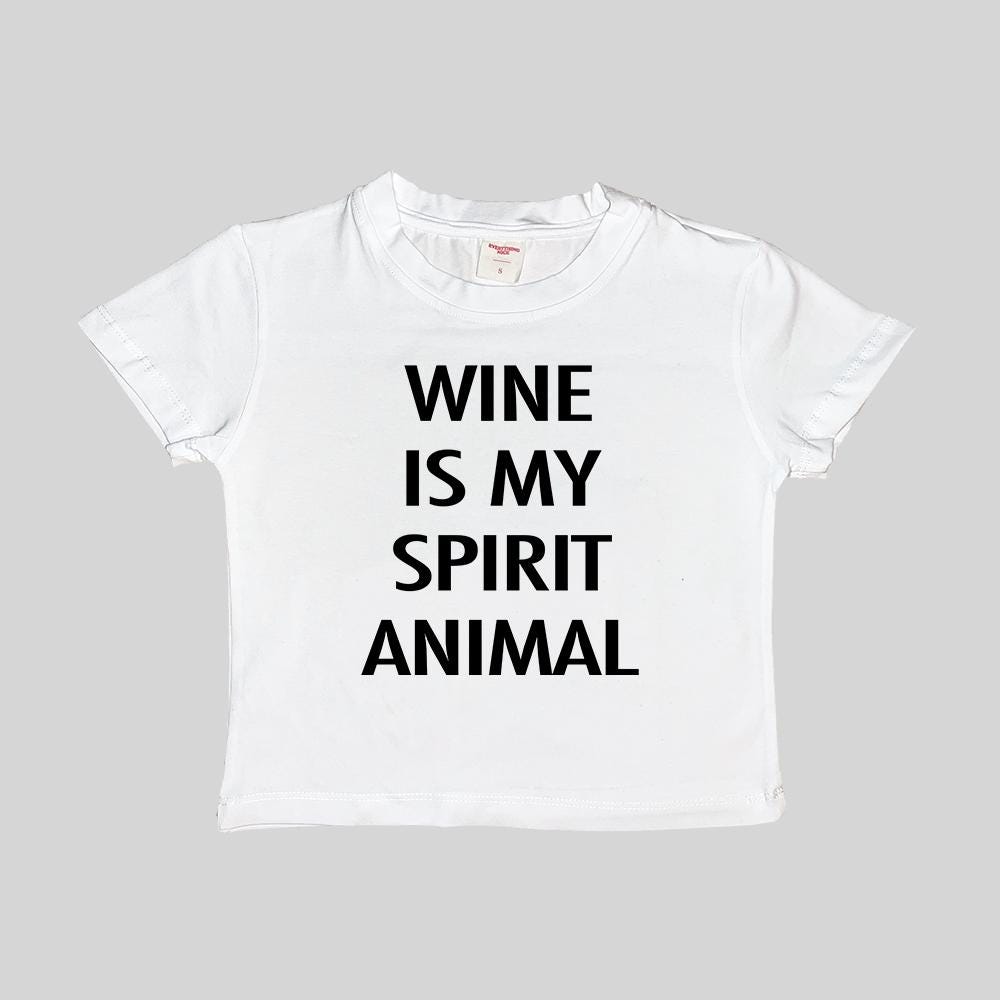 White cropped baby T-shirt with “WINE IS MY SPIRIT ANIMAL” in bold black letters.