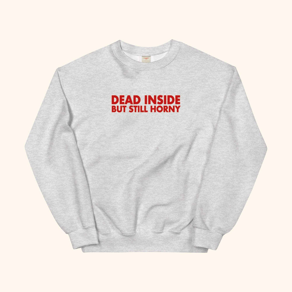 Gray sweatshirt with red “DEAD INSIDE BUT STILL HORNY” graphic on front