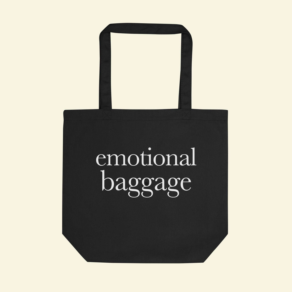 Black tote bag with short handles, featuring “emotional baggage” printed on the front.