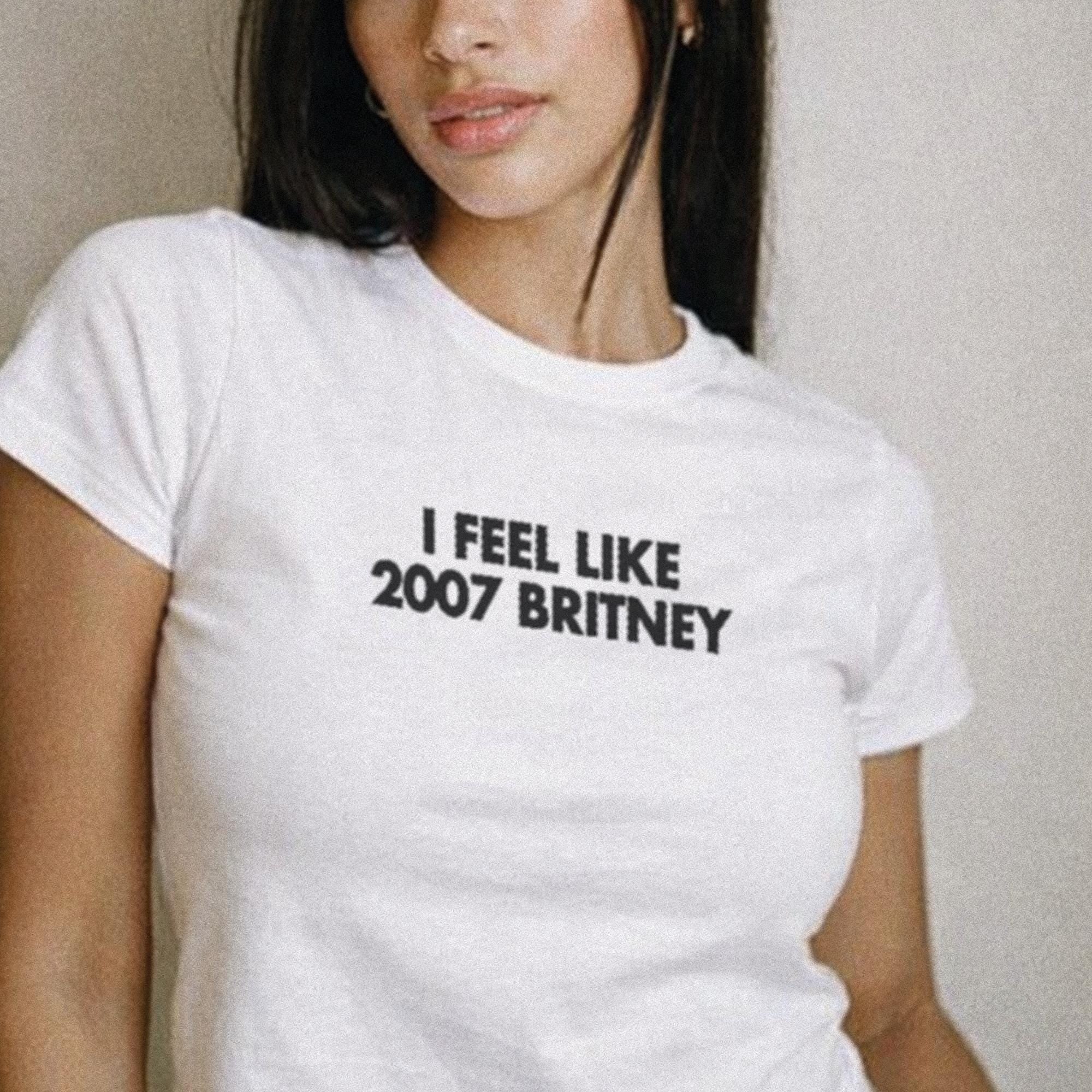 White crop baby T-shirt with “I FEEL LIKE 2007 BRITNEY” front graphic.