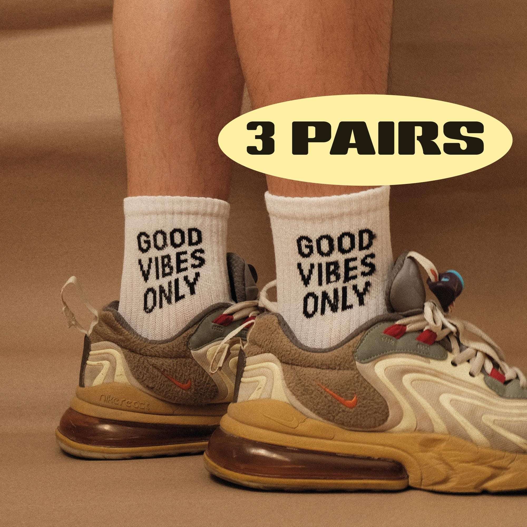 White socks with 'GOOD VIBES ONLY' print on cuffs, worn with sneakers