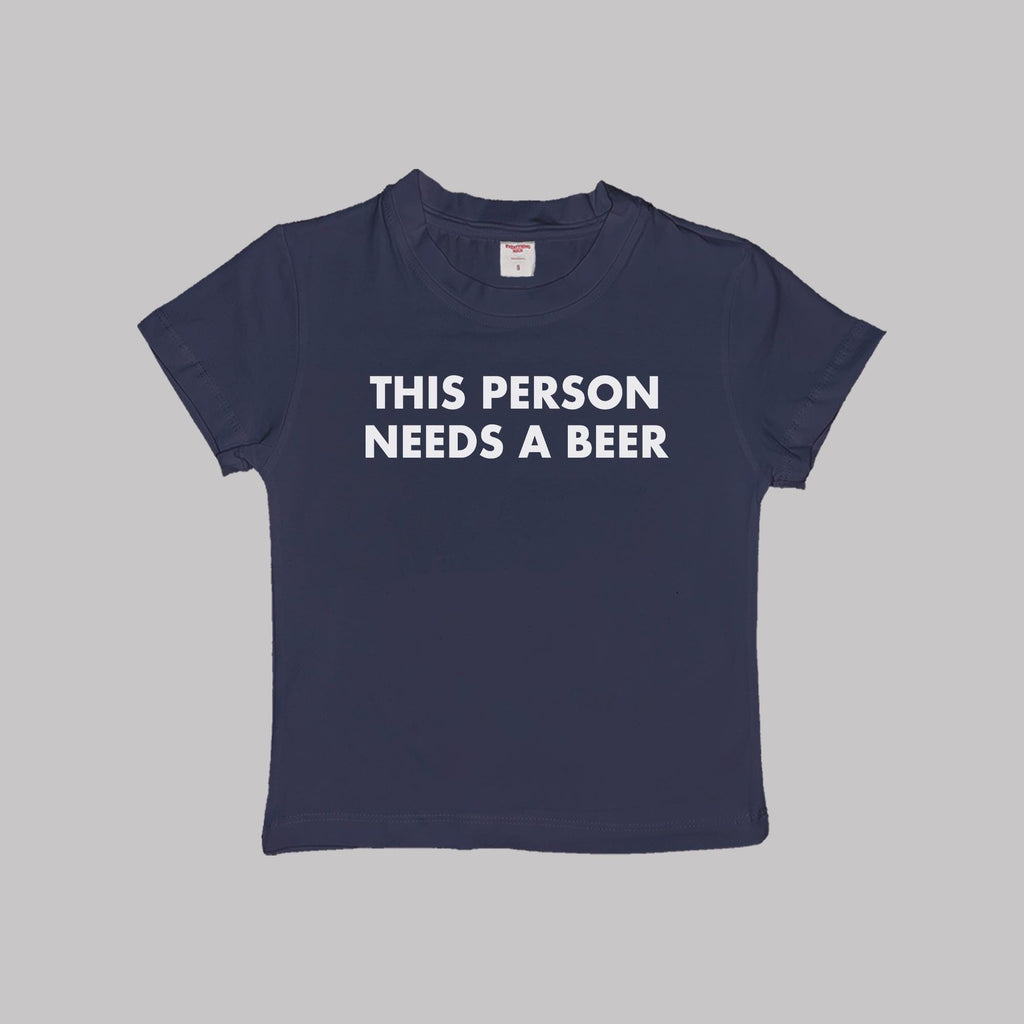 Navy cropped baby tee with “THIS PERSON NEEDS A BEER” text print