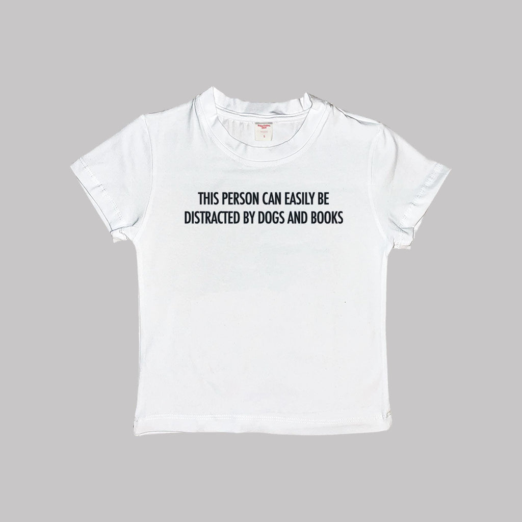 White baby T-shirt with “Dogs and books” slogan on the front