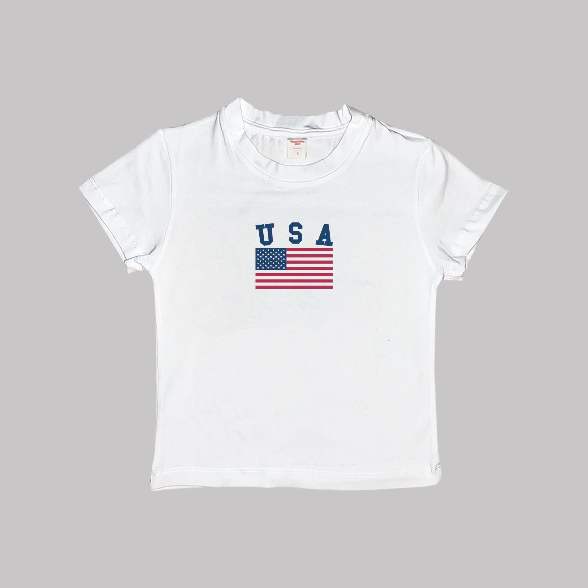 White baby crop tee with USA flag and USA letters graphic