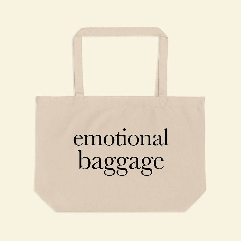 Beige tote bag with short handles and “emotional baggage” printed across the front.