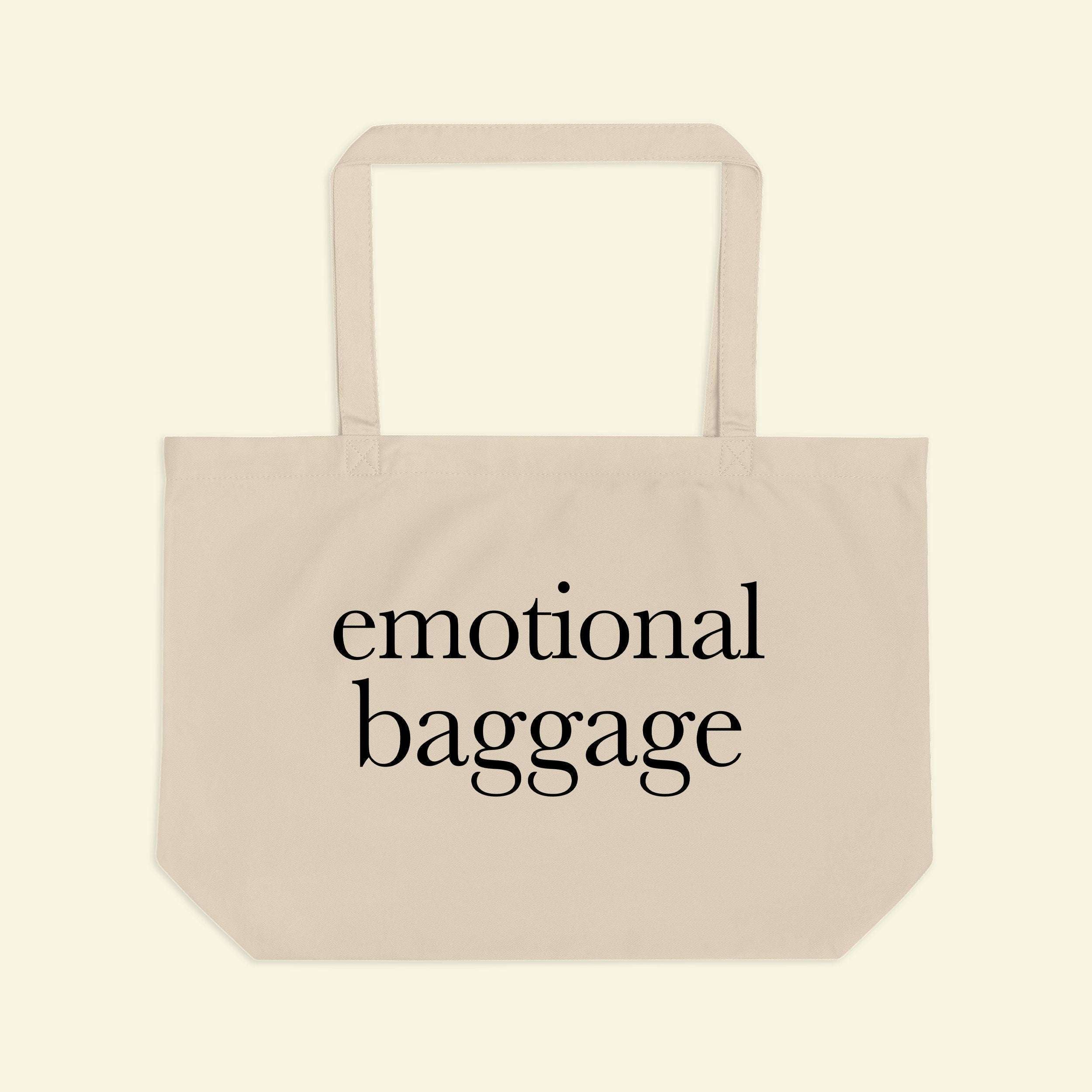 Beige tote bag with short handles and “emotional baggage” printed across the front.