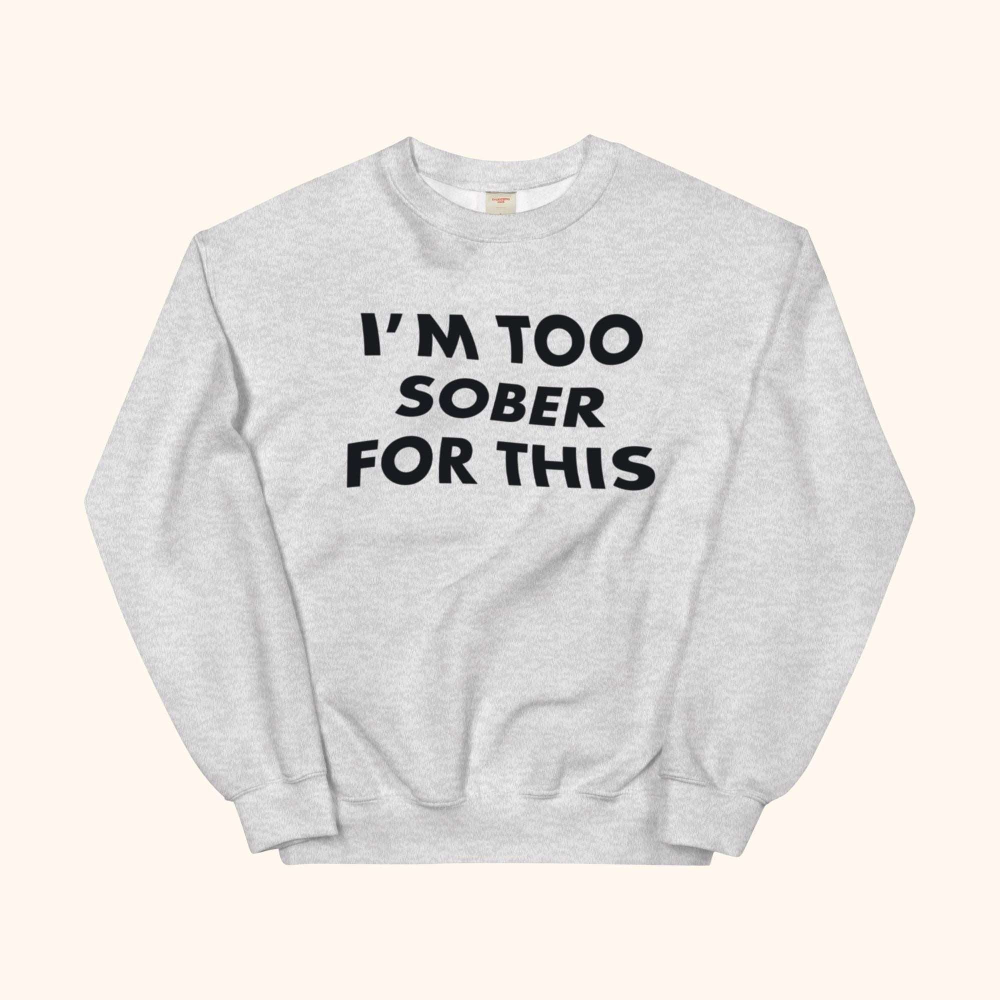 Gray crewneck sweatshirt with bold black slogan graphic on the front