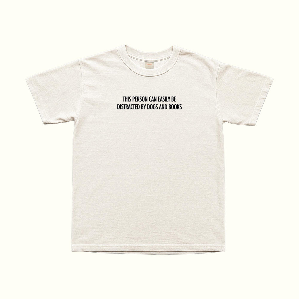 White short-sleeve T-shirt with “This person can easily be distracted by dogs and books”
