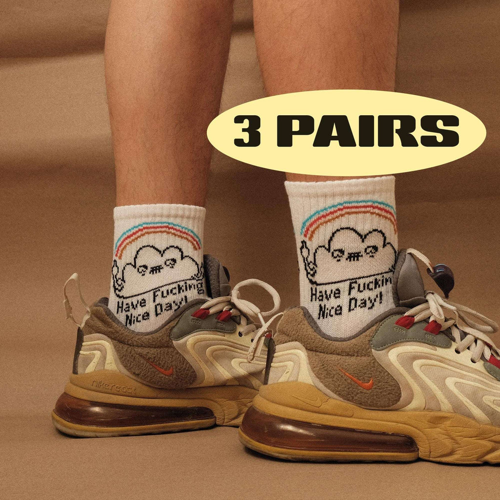 White crew socks with rainbow-striped trim and smiling face graphic; 'Nice Day' text