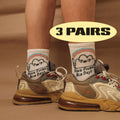 White crew socks with rainbow-striped trim and smiling face graphic; 'Nice Day' text