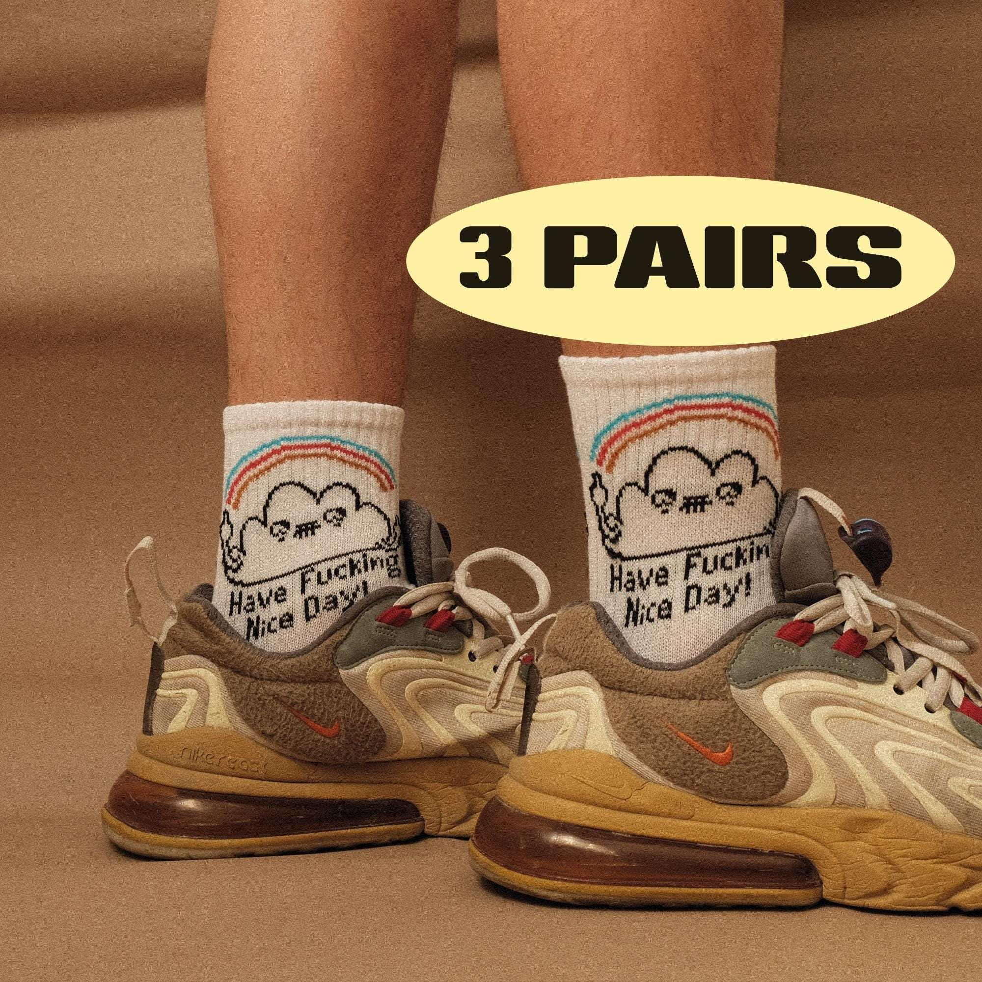 White crew socks with rainbow-striped trim and smiling face graphic; 'Nice Day' text