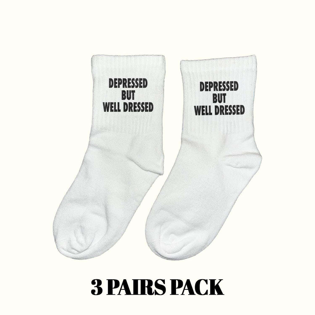 White crew socks with black 'DEPRESSED BUT WELL DRESSED' text, 3-pack