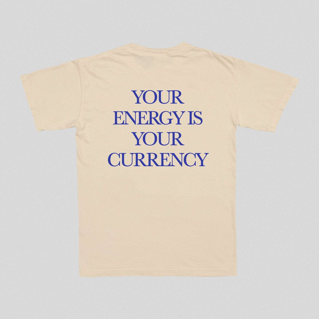 Natural/beige T-shirt with blue text “YOUR ENERGY IS YOUR CURRENCY”.