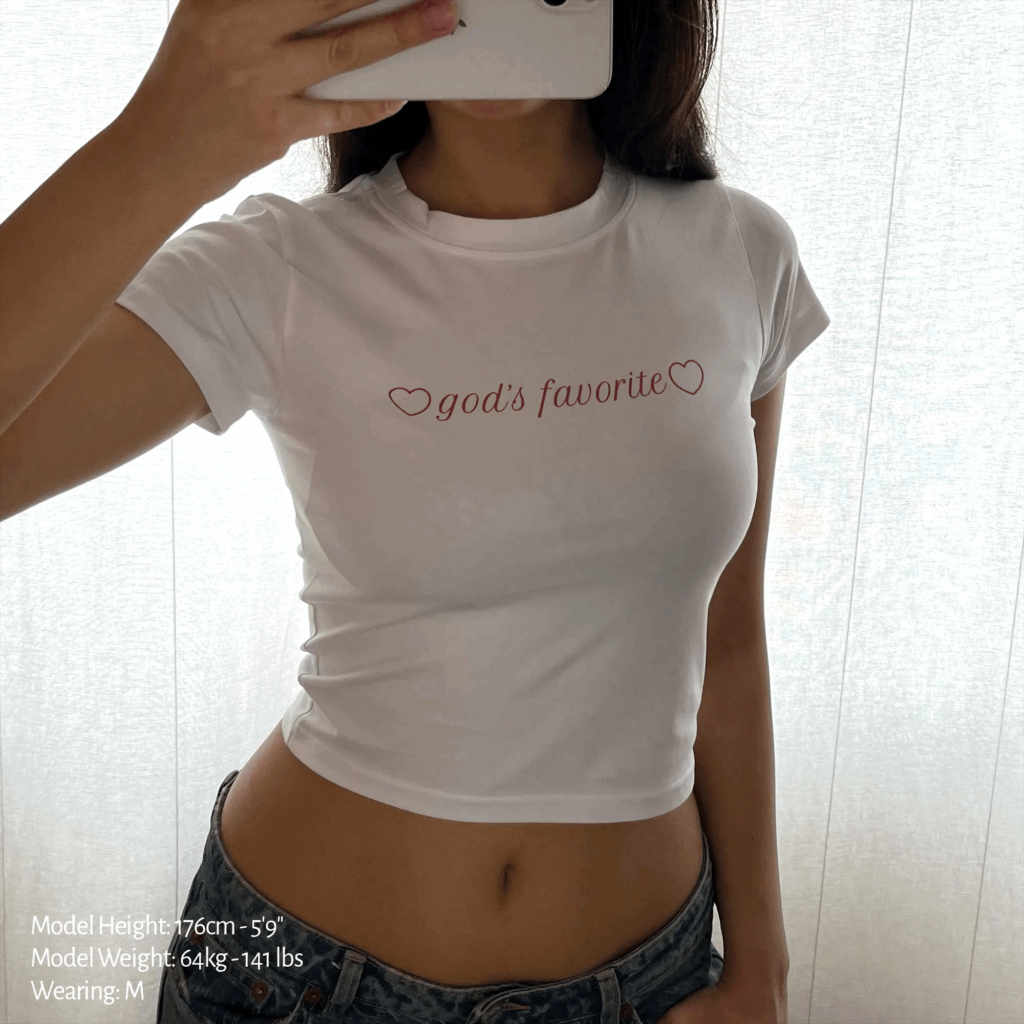 White baby tee crop top with "god's favorite" heart graphic on front