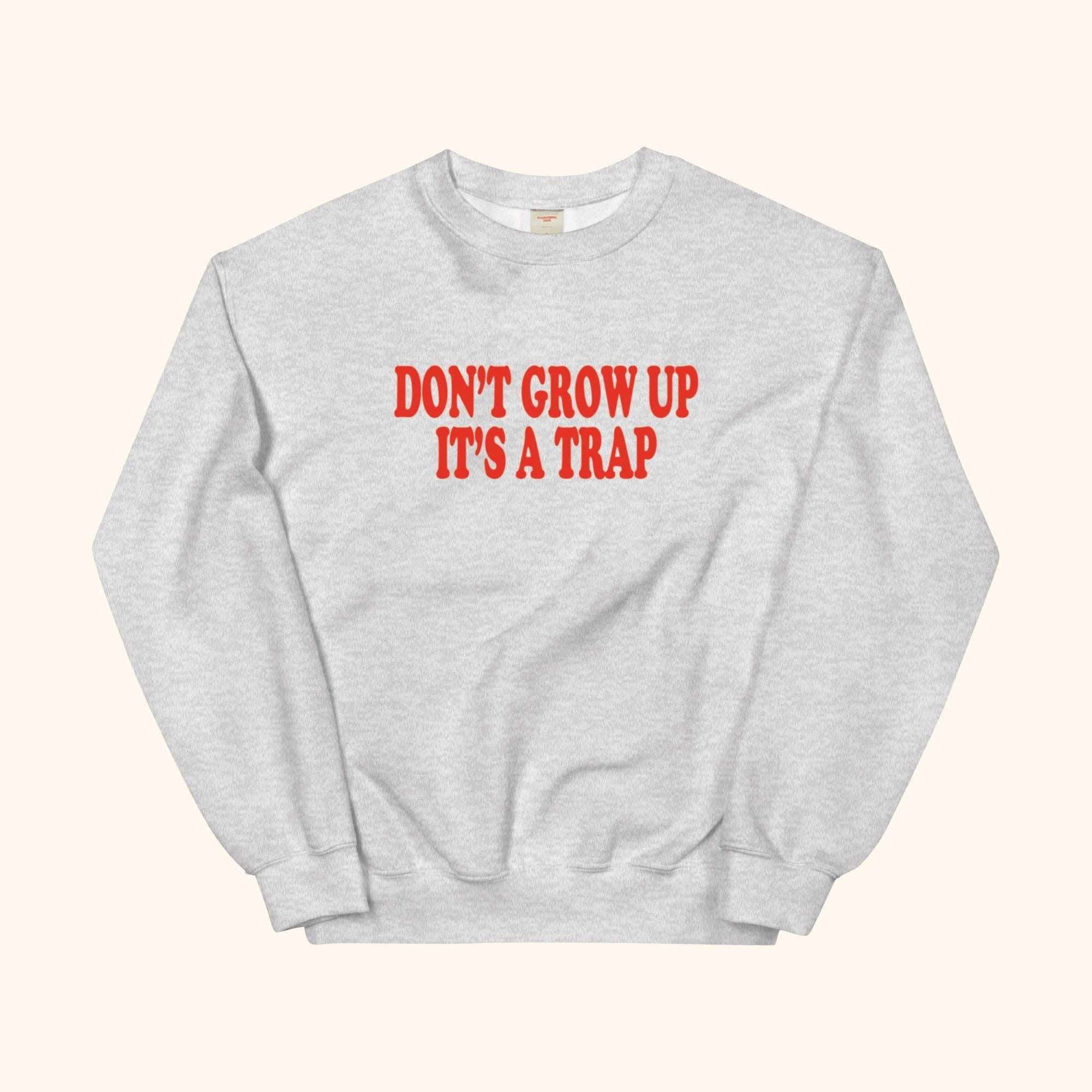 Gray sweatshirt with red "DON'T GROW UP ITS A TRAP" graphic