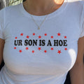 White baby tee with red stars and 'UR SON IS A HOE' front print