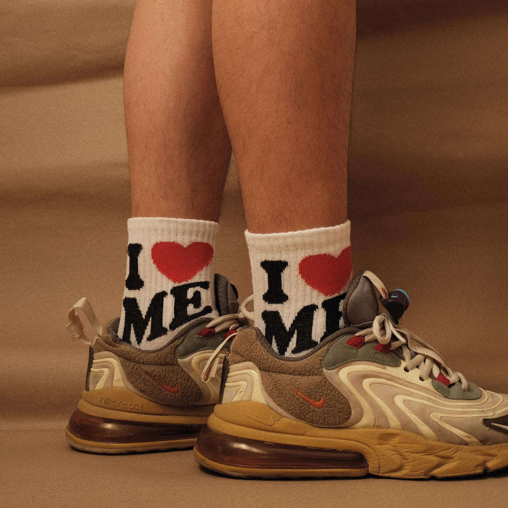 Crew socks showing "I ME" letters with a red heart on white with black trim