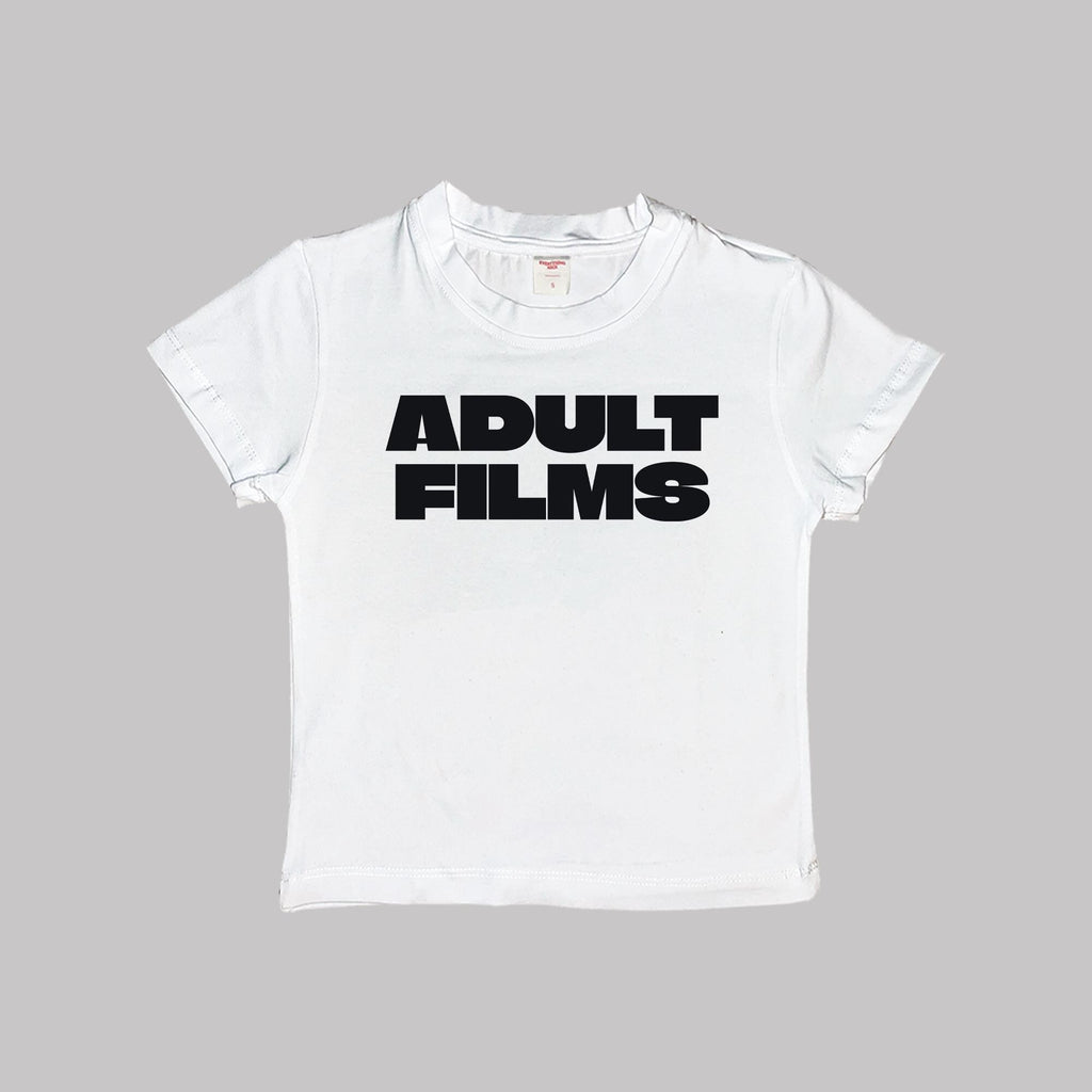White baby tee crop top, flat lay, black “ADULT FILMS” logo