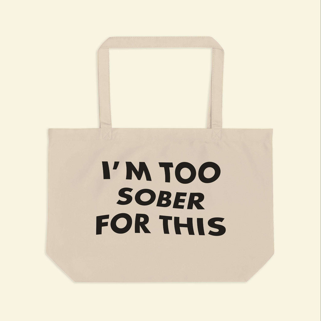 Beige canvas tote bag with black slogan print and two handles