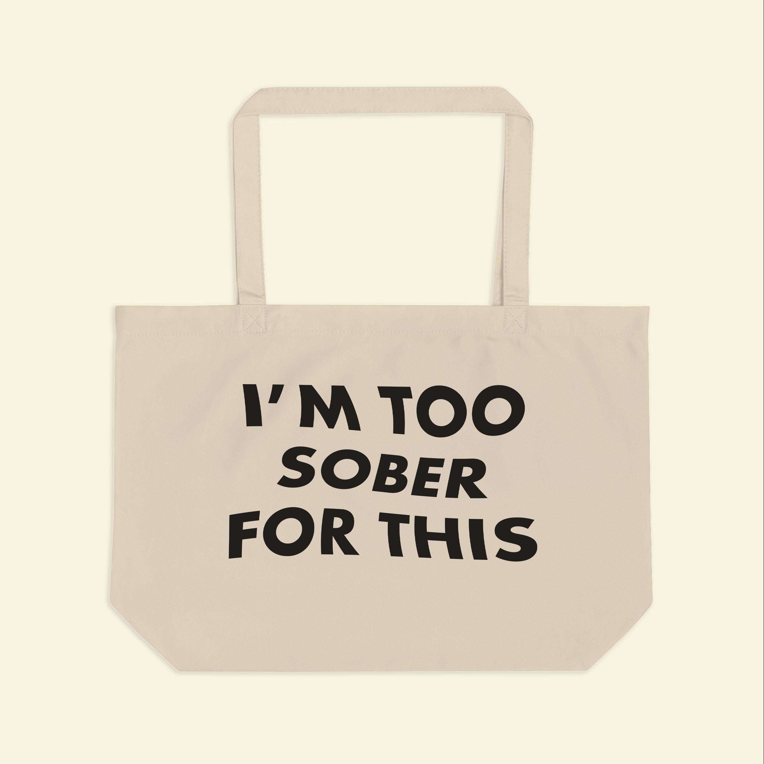 Beige canvas tote bag with black slogan print and two handles