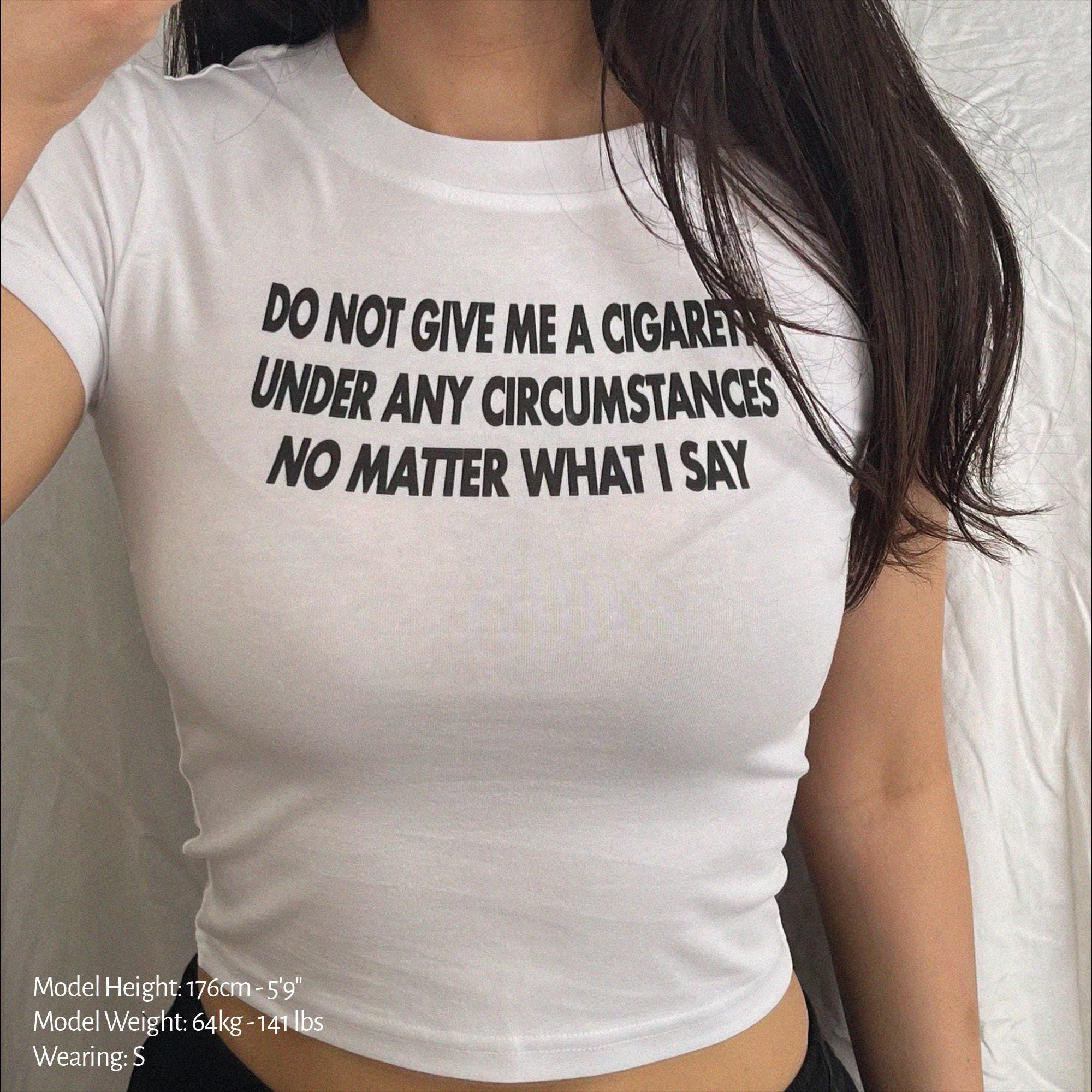 White baby tee crop top with bold black slogan text on the chest