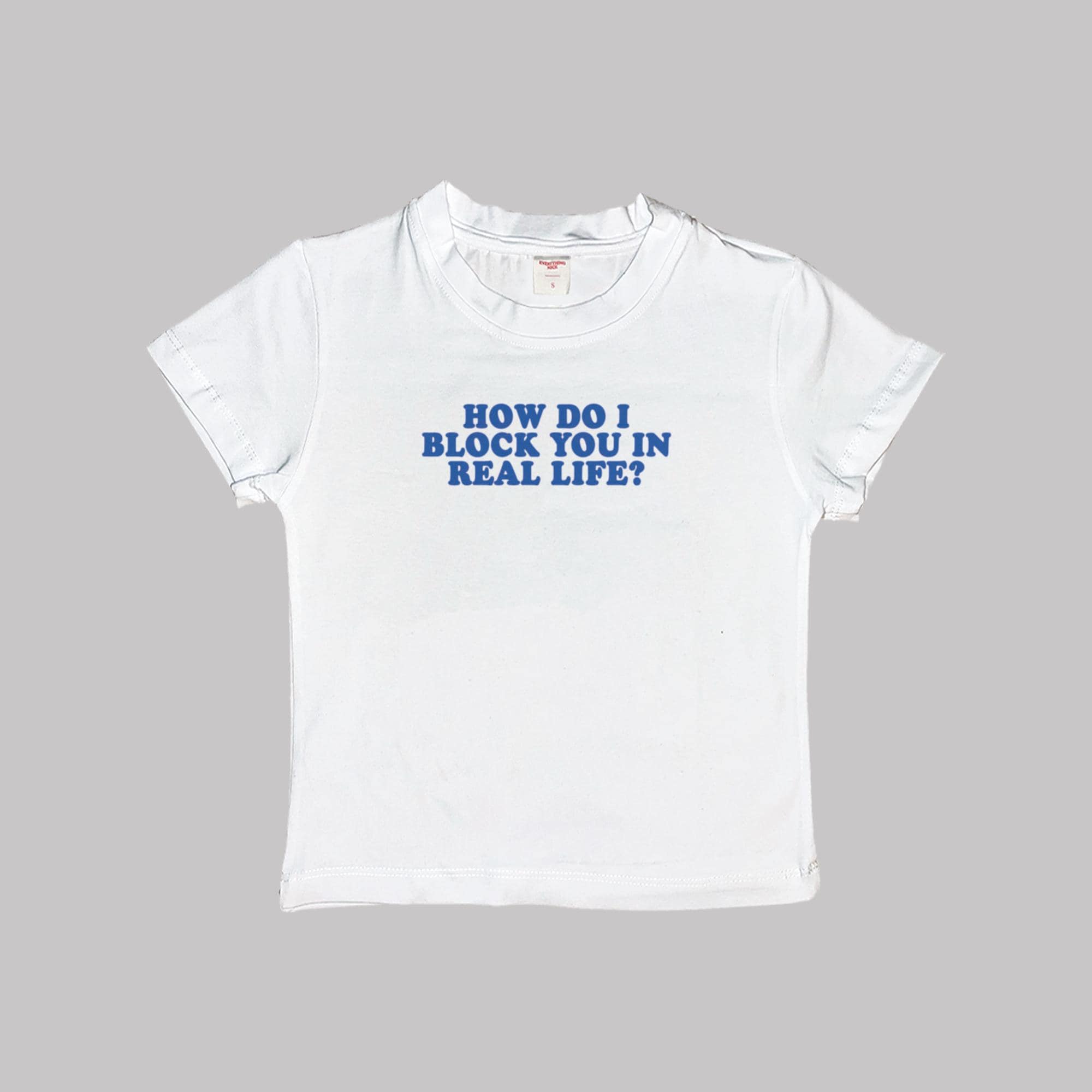 White crop baby tee, 'HOW DO I BLOCK YOU IN REAL LIFE?' blue graphic.