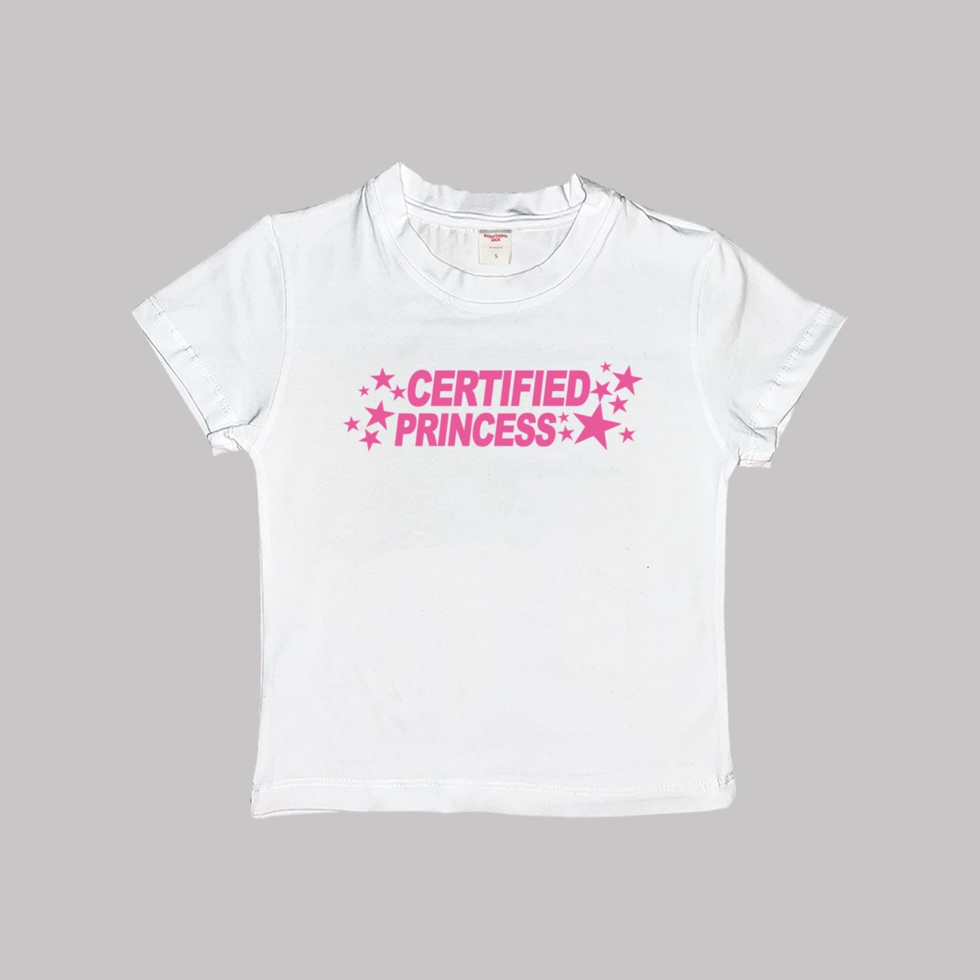 White short-sleeve crop baby tee with 'CERTIFIED PRINCESS' pink star text.