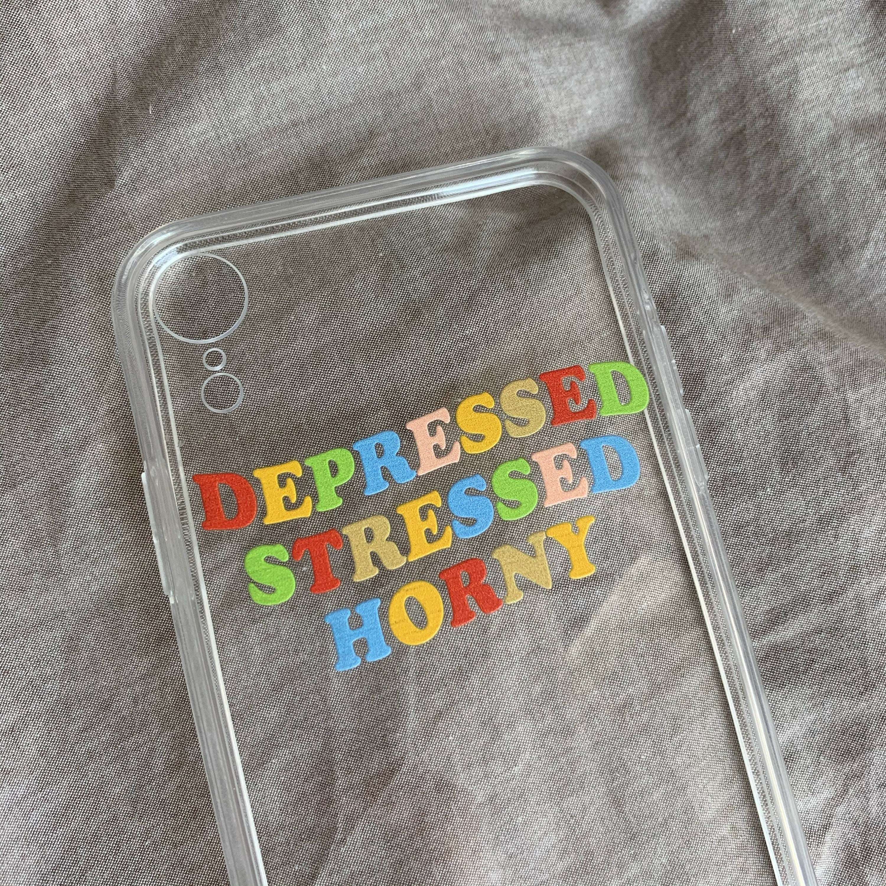 iPhone case with colorful 'DEPRESSED STRESSED HORNY' text and camera cutout